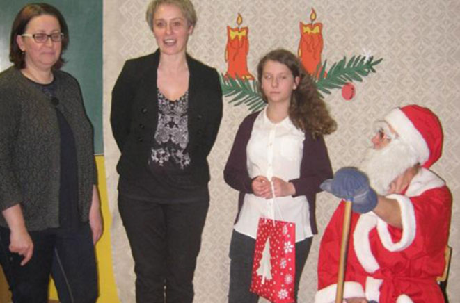 Mokytojos Birutė Oluv ir Teresė Jonuškienė bei Kalėdų Senelio pagalbininkė Justina Marteckaitė su Kalėdų Seneliu